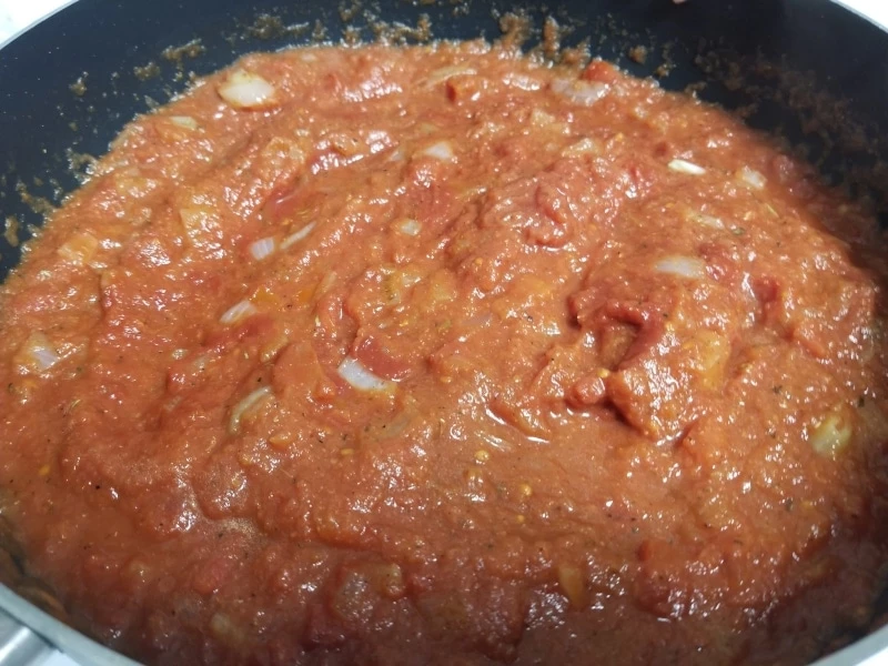 Crushed tomatoes in a pan warming