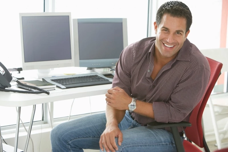 Man sitting at a desk with two monitors