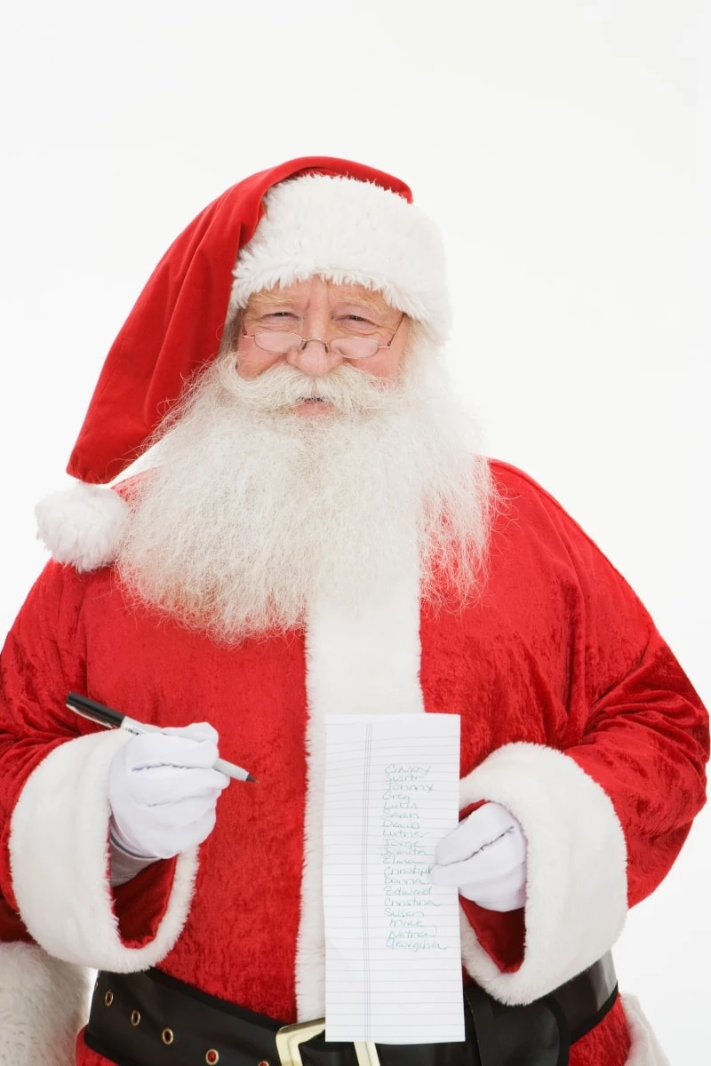 Santa holding a list of names and a pen