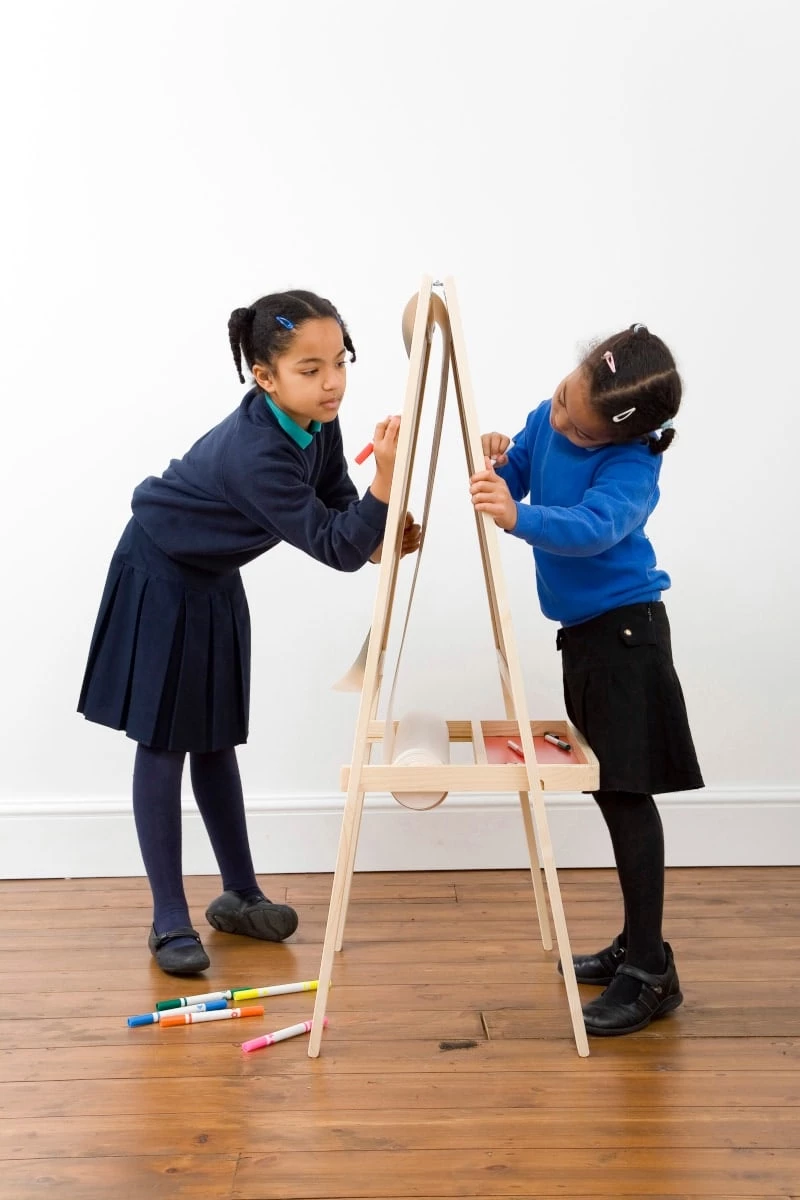 Two girls drawing at an easel