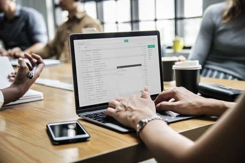Woman checking email while typing on laptop