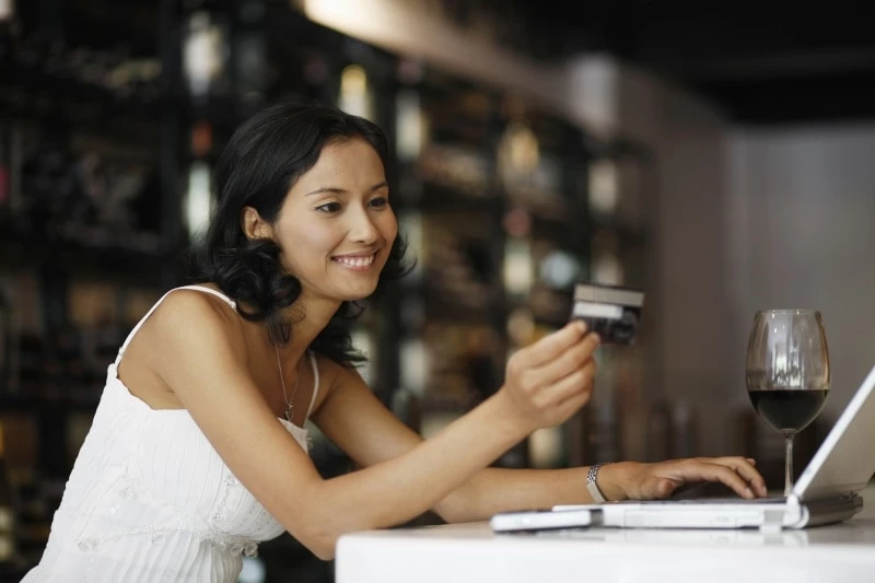 Woman holding a credit card and shopping online