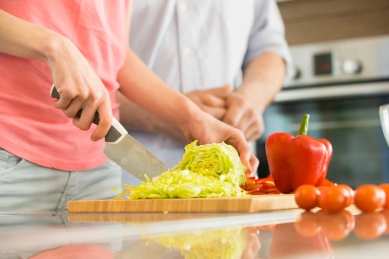 woman chopping cabbage on a cutting board