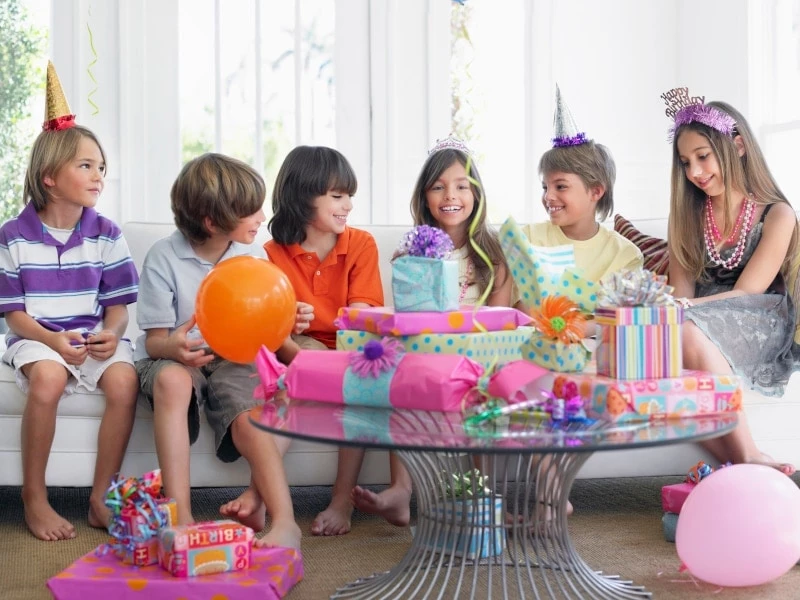 group of kids gathered around birthday girl and presents