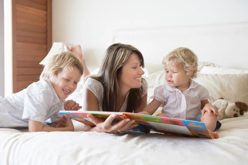 Mother teaching her two young sons to read