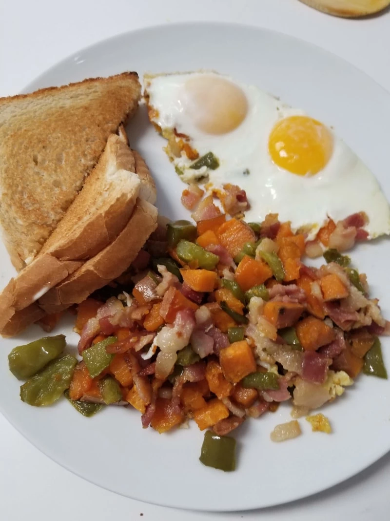 Sweet Potato Hash with 2 Over Medium Eggs and Toast on a plate