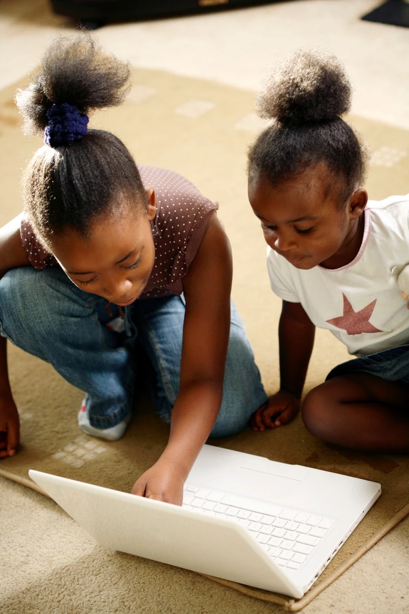 Two black girls looking at a laptop together