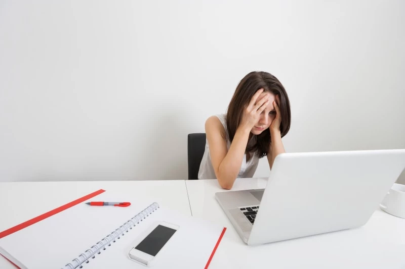 Stressed businesswoman with laptop at desk in office