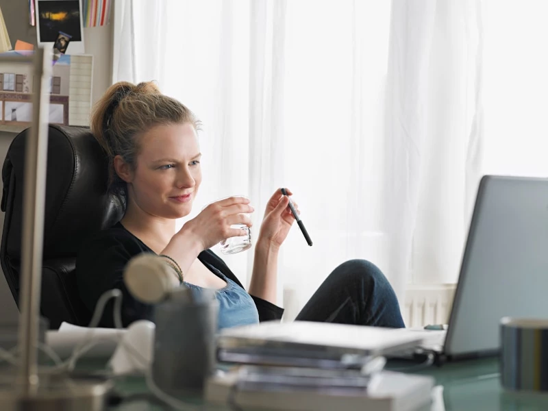 woman working at home while sipping coffee