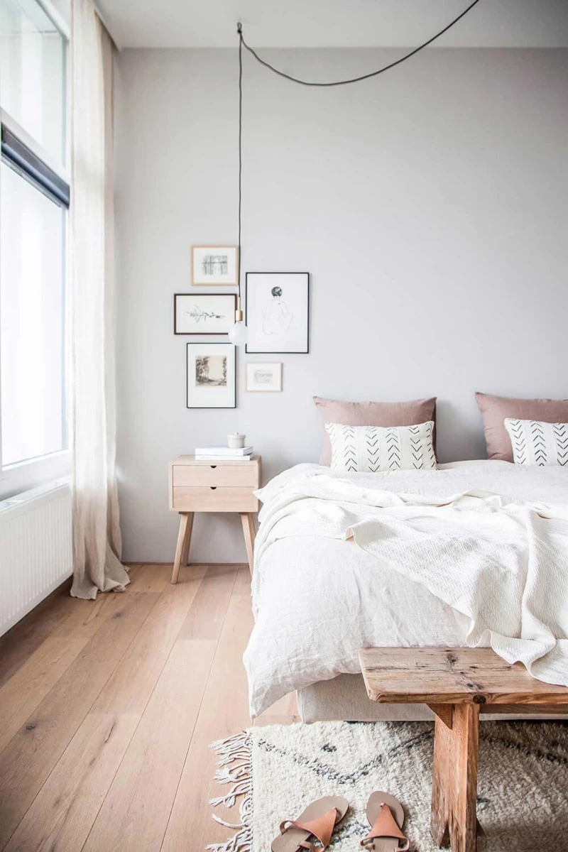 A Scandinavian styled bedroom with whites and natural wood tones with minimalist designs.