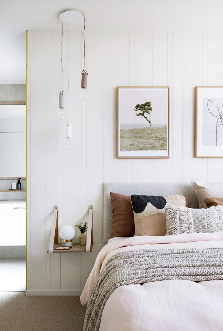 A Scandinavian styled bedroom with soft pinks and minimalist decor.