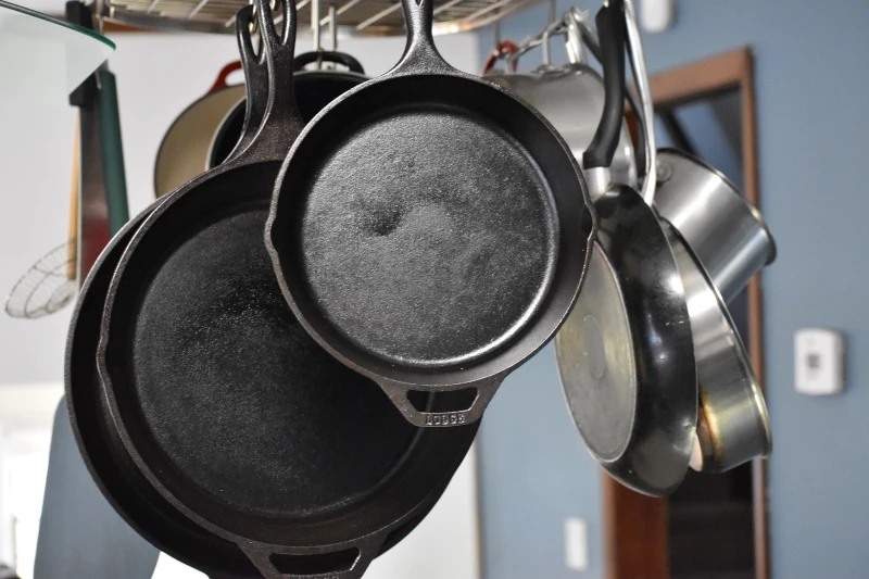 cast iron skillets hanging from a pot rack
