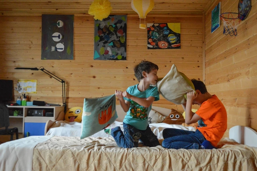 Two young brothers having a pillow fight in their room