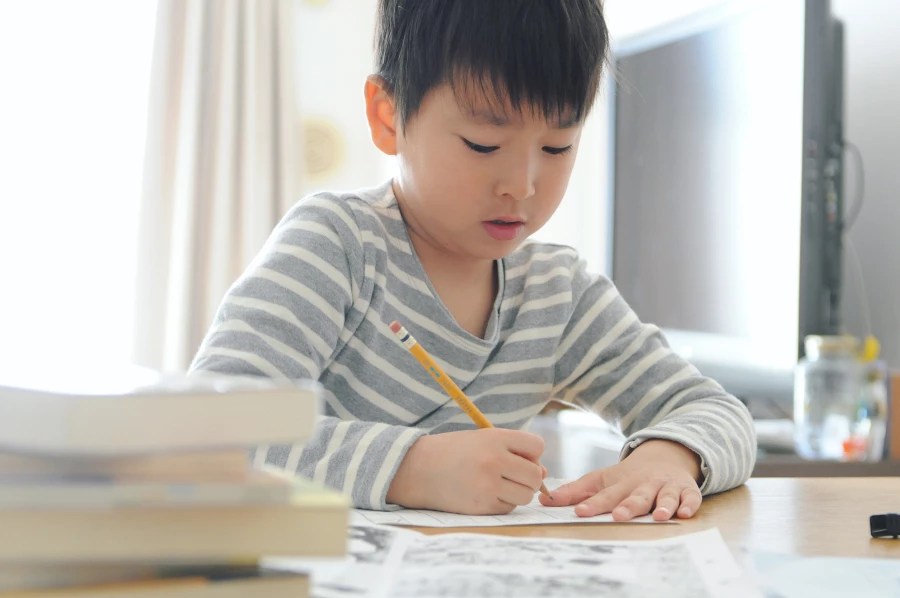 Child writing on paper at a desk