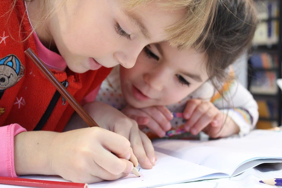 two children writing in a workbook