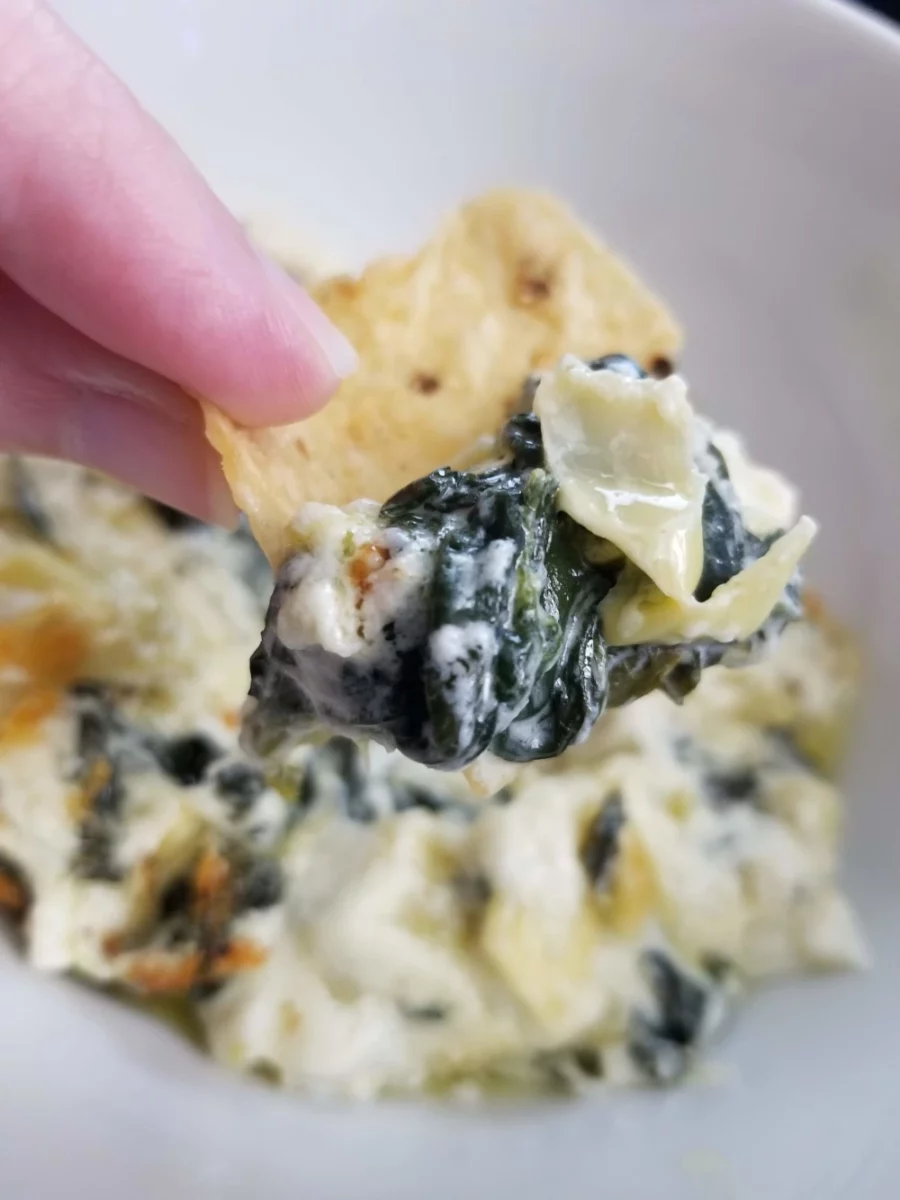 9 - Spinach artichoke dip scooped on a tortilla chip